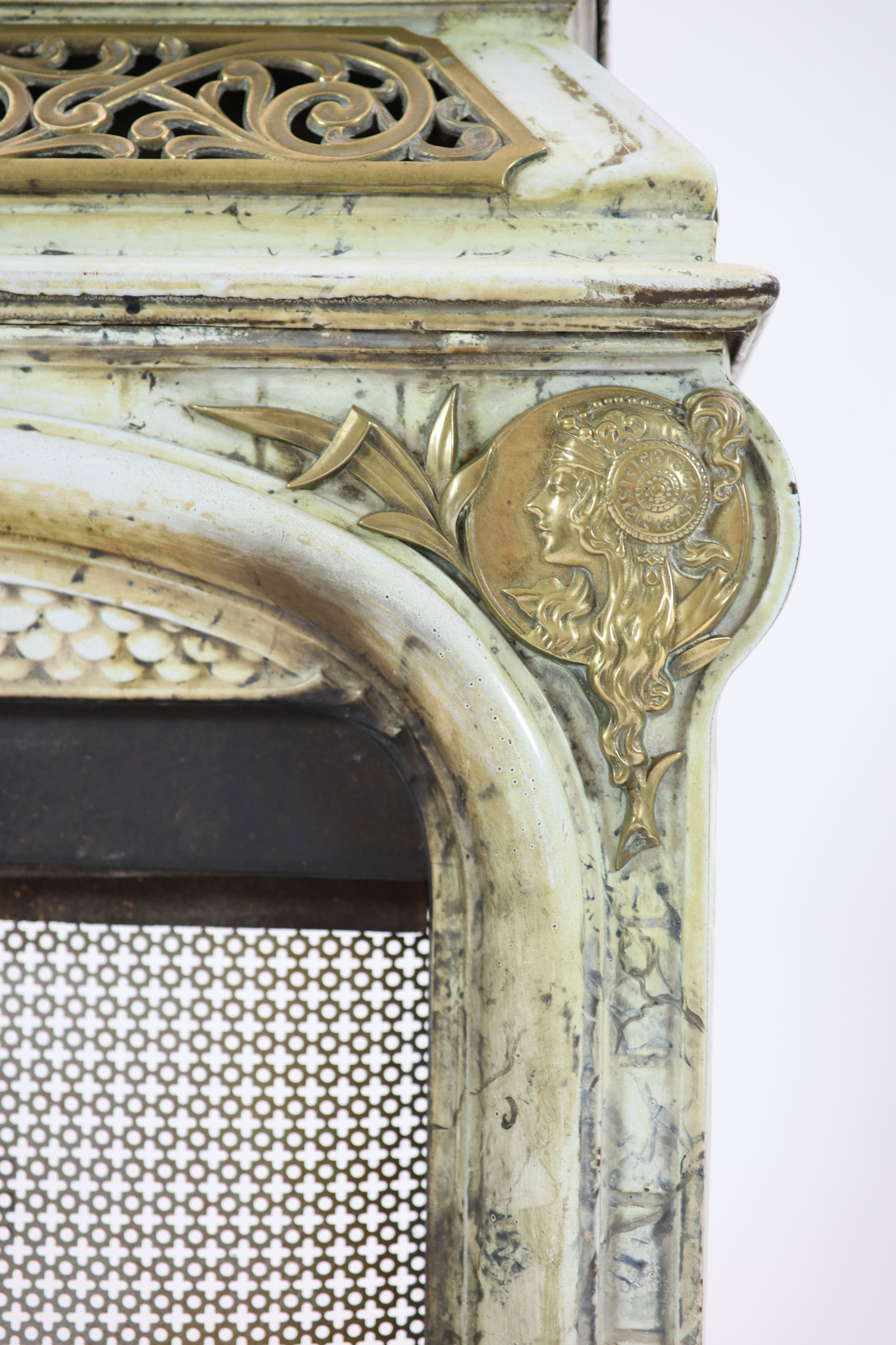 A late 19th century French Art Nouveau enamelled cast iron and brass fire surround H 91cm. W 82cm. D 46cm.